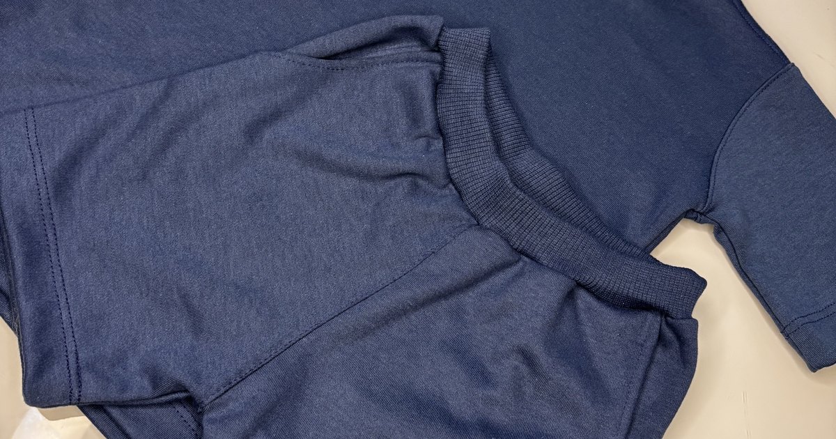 Blusa infantil Noma Mini de modelagem oversize dobrada sobre fundo claro