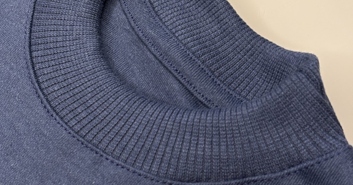 Close da gola canelada de uma blusa infantil Noma Mini índigo, sem etiqueta interna
